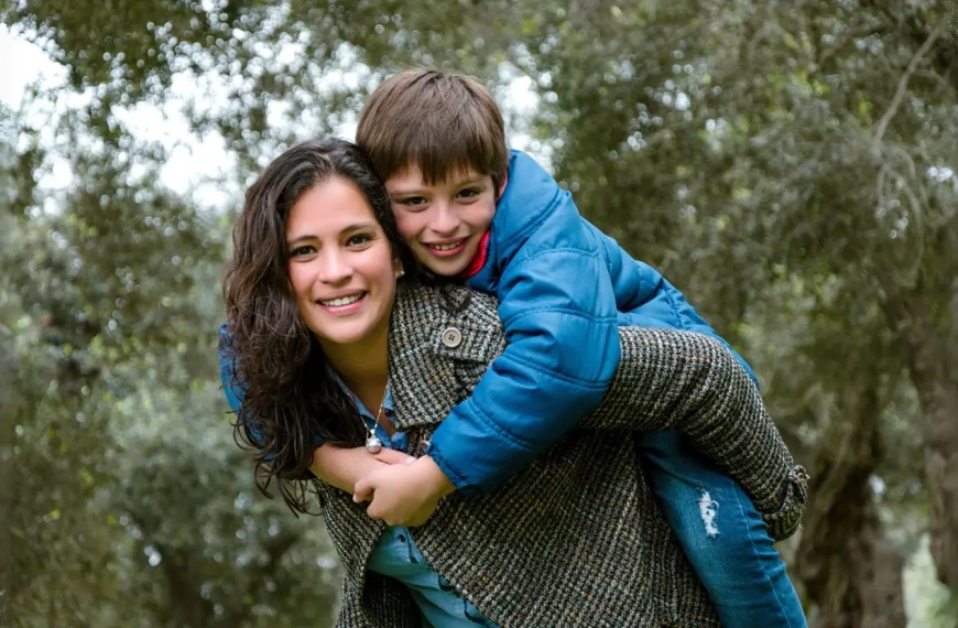 Sarah and her son looking happy in the woods