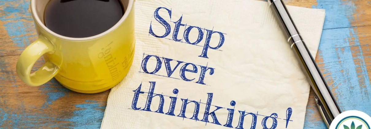 Coffee cup on a pc of paper saying OVERSTHINKING