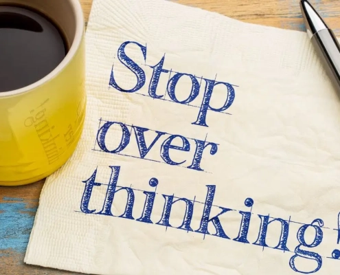 Coffee cup on a pc of paper saying OVERSTHINKING