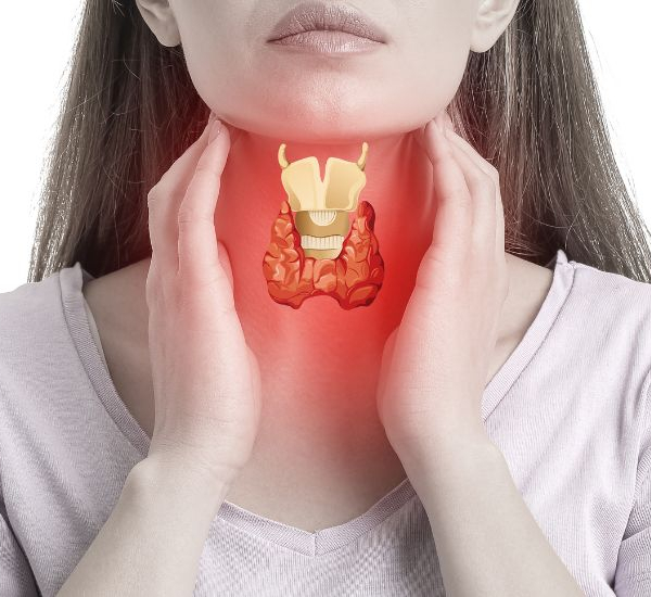 Woman holding her thyroid which seems inflammed