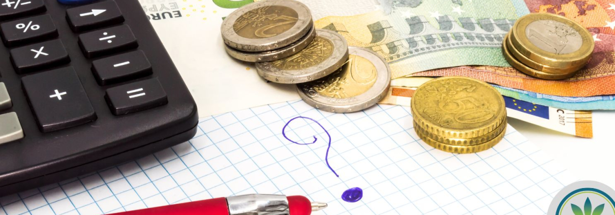 Calculator, money and a pen on top of a map