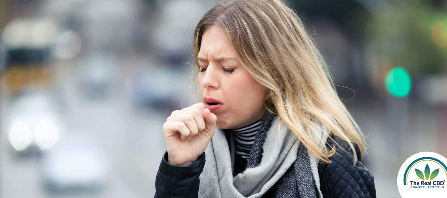 Woman coughing heavily into her hand