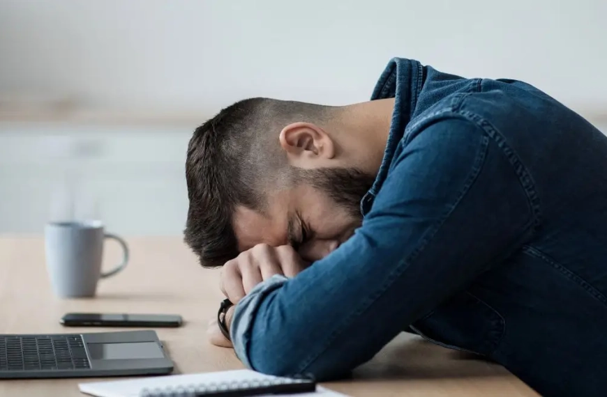 Man sleeping over an office table