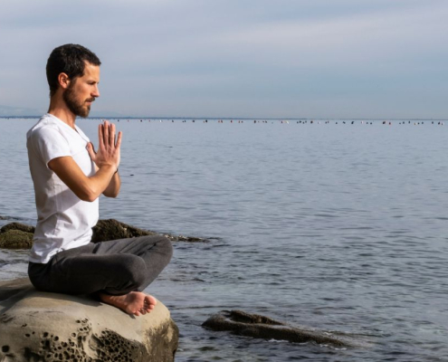 Man sitting on the beach doing breathwork