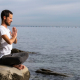 Man sitting on the beach doing breathwork