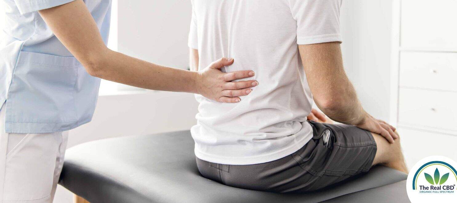 Fysio holding the lower back of a man in pain
