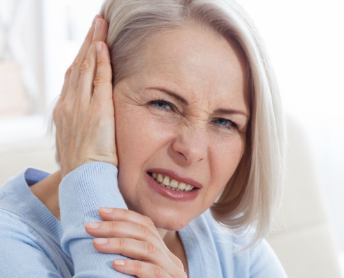 Woman holding the side of her head in pain