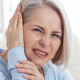 Woman holding the side of her head in pain