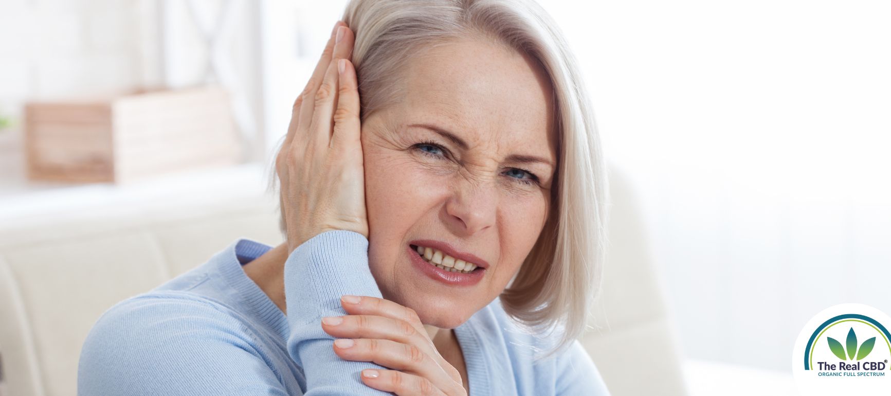 Woman holding the side of her head in pain