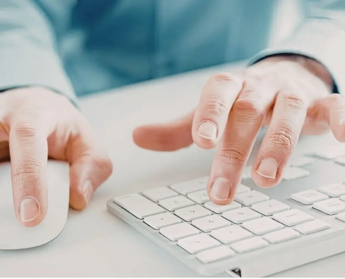 A set of hands working on a keyboard and a mouse