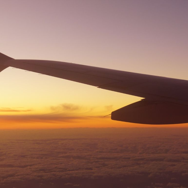 Wing of an aeroplane flying into a sunrise