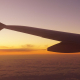 Wing of an aeroplane flying into a sunrise