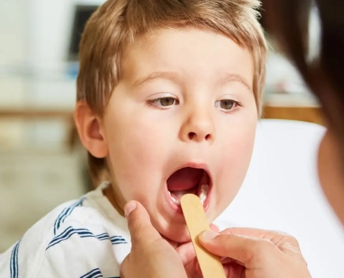Boy being examined in his throath by his doctor