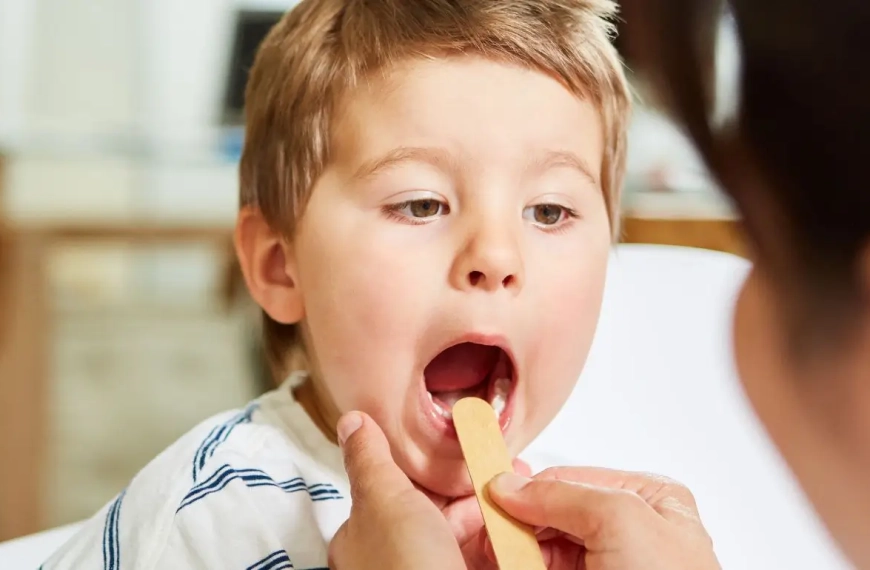Boy being examined in his throath by his doctor