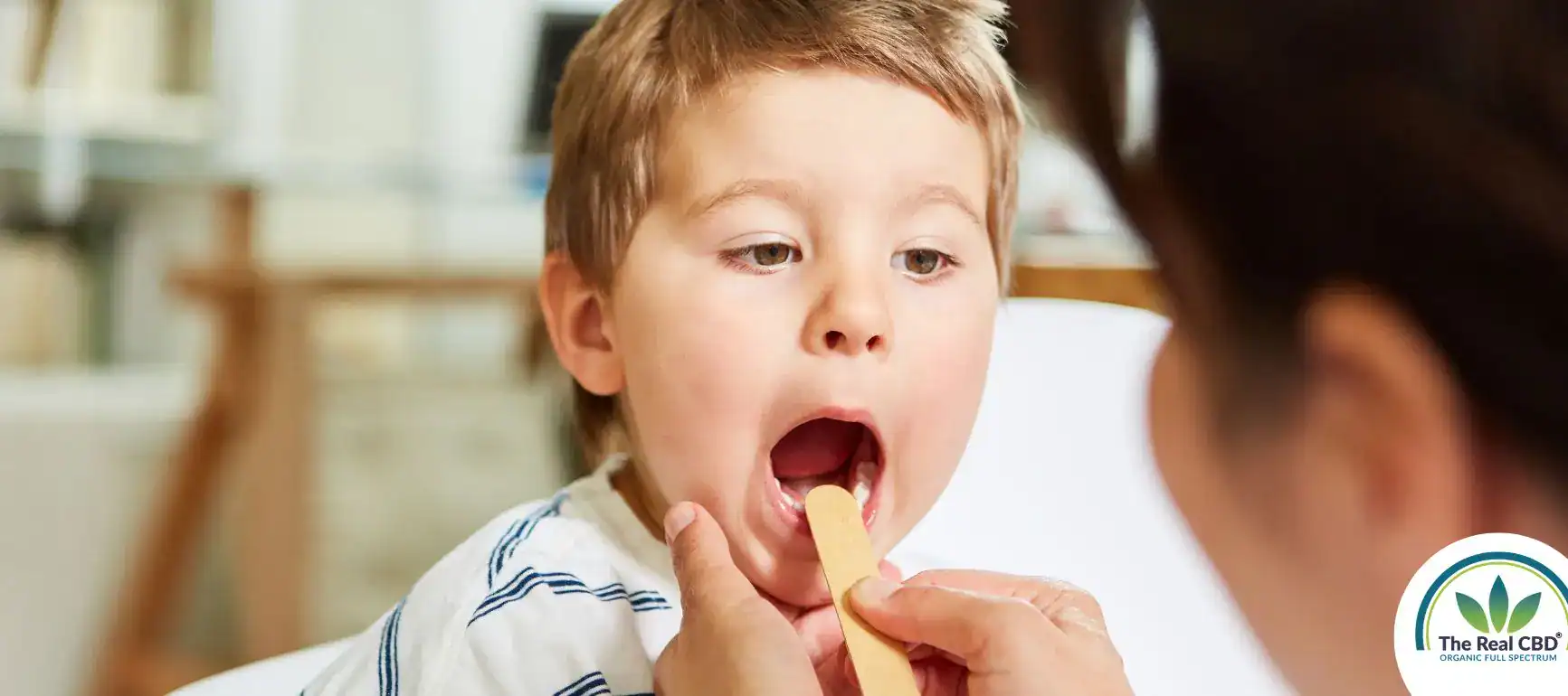 Boy being examined in his throath by his doctor